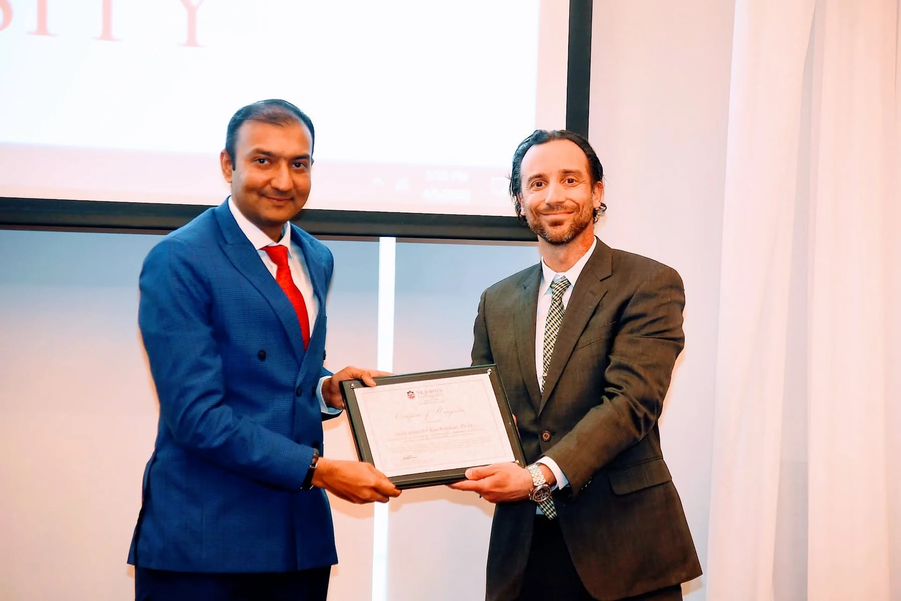 Dr. Bukhari receiving an academic recognition