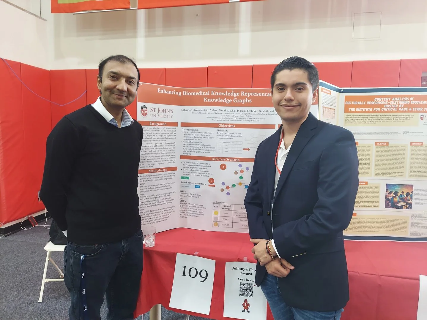 Dr. Bukhari with a student presenter beside a biomedical knowledge graph poster